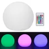 A white spherical lamp with a remote control is shown, along with three examples of the lamp illuminated in green, pink, and purple. Podgląd zdjęcia produktu