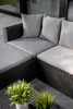 A close-up view of a dark brown rattan sectional outdoor sofa with gray cushions and pillows, set on a gray tiled patio. Náhled obrázku produktu