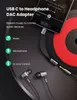 A USB-C to headphone adapter is shown connected to a smartphone, with earphones also connected to the adapter. The background appears to be a vinyl record. Produktbild-Vorschau
