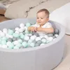 A baby playing in a ball pit. Produktbild-Vorschau