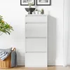 A white shoe cabinet with four flip-out drawers stands against a white wall. A woven basket with blankets is placed to the left of the cabinet, and a plant is on top of the cabinet. Náhľad obrázku produktu