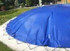 A blue pool cover is shown on a patio with grass and bushes in the background. Produktbild-Vorschau