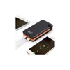 A black and orange power bank is shown charging two smartphones. Náhled obrázku produktu