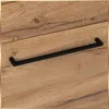A close-up shot of a black handle on a wooden surface. Podgląd zdjęcia produktu