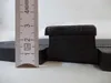 A close-up view of a black cast iron grate with a ruler for scale. Voir les images du produit