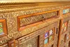 A close-up view of an ornate wooden sideboard with intricate gold carvings and colorful tiled panels. Produktbild-Vorschau