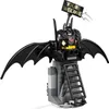 A LEGO Batman figure with wings and a sign that says "YOU'RE WELCOME" is mounted on a gray structure with a ladder. Produktbild-Vorschau