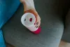 A person holding a pink and white thermos cup. Náhled obrázku produktu