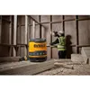 A construction worker is using a drill in a room with wooden walls, while a DeWalt speaker sits in the foreground. Podgląd zdjęcia produktu