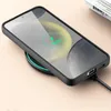 A smartphone in a black case is wirelessly charging on a charging pad. The phone screen shows a charging icon and '100%'. Produktbild-Vorschau
