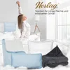 A woman in pajamas stretching in a bedroom with bedding and pillows. Produktbild-Vorschau