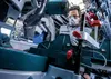 A person is using a miter saw to cut material. Voir les images du produit