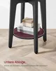A close-up view of the lower section of a black side table, showing a round burgundy shelf with books and a small box on it. Produktbild-Vorschau