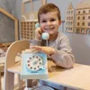 A young boy is playing with a toy telephone in a room with wooden decorations. Produktbild-Vorschau