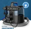 A close-up marketing image of a carpet and upholstery cleaner, showing its attachments and a power cord with a plug icon indicating its reach. Produktbild-Vorschau