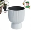 A white ribbed planter with a black insert, shown next to a smaller black planter with a plant, and a cartoon gardener. Produktbild-Vorschau