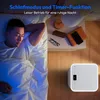 A man sleeping in bed next to a nightstand with a smart device on the floor. Produktbild-Vorschau