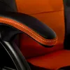 A close-up shot of the armrest of an orange and black office chair. Produktbild-Vorschau