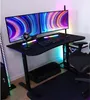 A gaming desk setup with dual monitors, keyboard, mouse, and microphone, illuminated by RGB lighting. Voir les images du produit