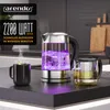 A modern kitchen counter with a glass electric kettle boiling water, a steaming mug, and a tea infuser. Voir les images du produit