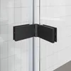A close-up view of a black hinge on a glass shower door, set against a tiled wall. Anteprima dell’immagine prodotto