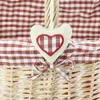 Close-up of a wicker basket with a red and white gingham lining and a heart-shaped decoration. Produktbild-Vorschau