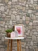 A small table with decorative items in front of a stone-patterned wall. Produktbild-Vorschau