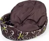 A brown oval dog bed with a patterned exterior and a plush brown cushion inside, shown on a white background. Produktbild-Vorschau