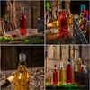 A collage of four images showcasing glass bottles filled with various colored liquids, arranged in rustic settings with wood and straw elements. Produktbild-Vorschau