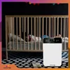 A child sleeping in a crib next to an air purifier. Podgląd zdjęcia produktu