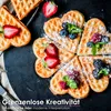Heart-shaped waffles topped with berries and powdered sugar, arranged on a dark surface. Náhľad obrázku produktu