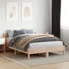 A bedroom scene with a wooden bed frame, bedding, and artwork on the wall. Produktbild-Vorschau