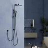 A black shower system is mounted on a light blue wall, with a dark blue tiled wall and bathroom vanity in the background. Podgląd zdjęcia produktu