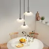A dining table with chairs and pendant lights above. Anteprima dell’immagine prodotto