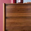 A close-up view of a wooden dresser with four drawers, showing the wood grain and texture. Anteprima dell’immagine prodotto