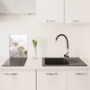 A kitchen counter with a sink, faucet, and a glass cutting board with an orchid image. Voir les images du produit
