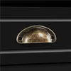 A close-up view of a drawer handle on a black piece of furniture. Produktbild-Vorschau