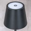 Close-up of the top of a black LED table lamp with a white touch-sensitive power button. Produktbild-Vorschau