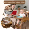 A mother and baby are in a kitchen setting. The baby is in a high chair, and the mother is feeding the baby. There are inset images showing the baby eating and cleaning the high chair. Produktbild-Vorschau