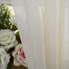 A close-up view of a sheer beige curtain with a bouquet of white and pink roses partially visible behind it. Produktbild-Vorschau