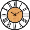 A close-up studio shot of a wall clock with a wooden face and black Roman numerals. Produktbild-Vorschau