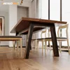 A dining table with dark wood top and black metal legs, set in a modern dining room with natural light. Voir les images du produit
