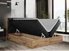 A modern bedroom with a boxspring bed with its storage compartment open, revealing the mattress and internal storage space. The bed is in a room with blinds, curtains, and a telescope in the background. Produktbild-Vorschau