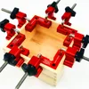 A set of red corner clamps is attached to a wooden box, demonstrating their use in woodworking. Náhled obrázku produktu