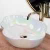 A pearlescent vessel sink with a gold faucet and drain. Náhľad obrázku produktu