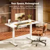 A modern home office setup with a white standing desk, a computer monitor, and a brown leather chair. Produktbild-Vorschau