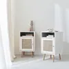 Two white bedside tables with rattan fronts are placed in a room with a white wall and a sheer curtain. Produktbild-Vorschau