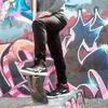 A person wearing Reebok work sneakers stands on a concrete structure in front of a graffiti-covered wall. Náhľad obrázku produktu