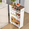 A slim storage cart filled with kitchen items is placed next to a kitchen counter. Anteprima dell’immagine prodotto