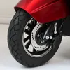 Close-up of the front wheel, brake disc, and part of the red body of a three-wheeled vehicle. Produktbild-Vorschau